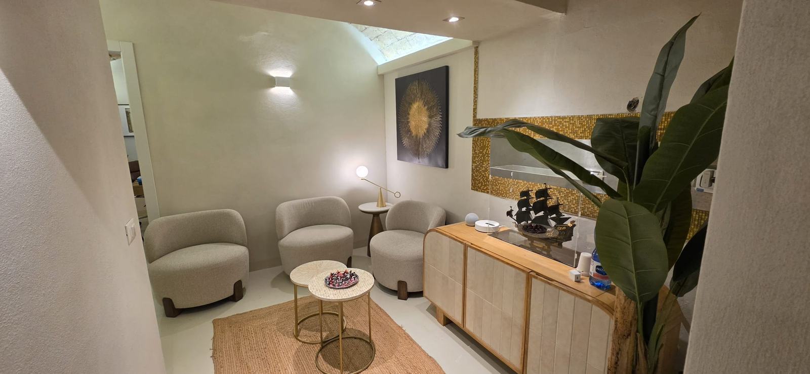 La sala d'attesa di MOSAICO con poltroncine in bouclé e tavolini in ottone